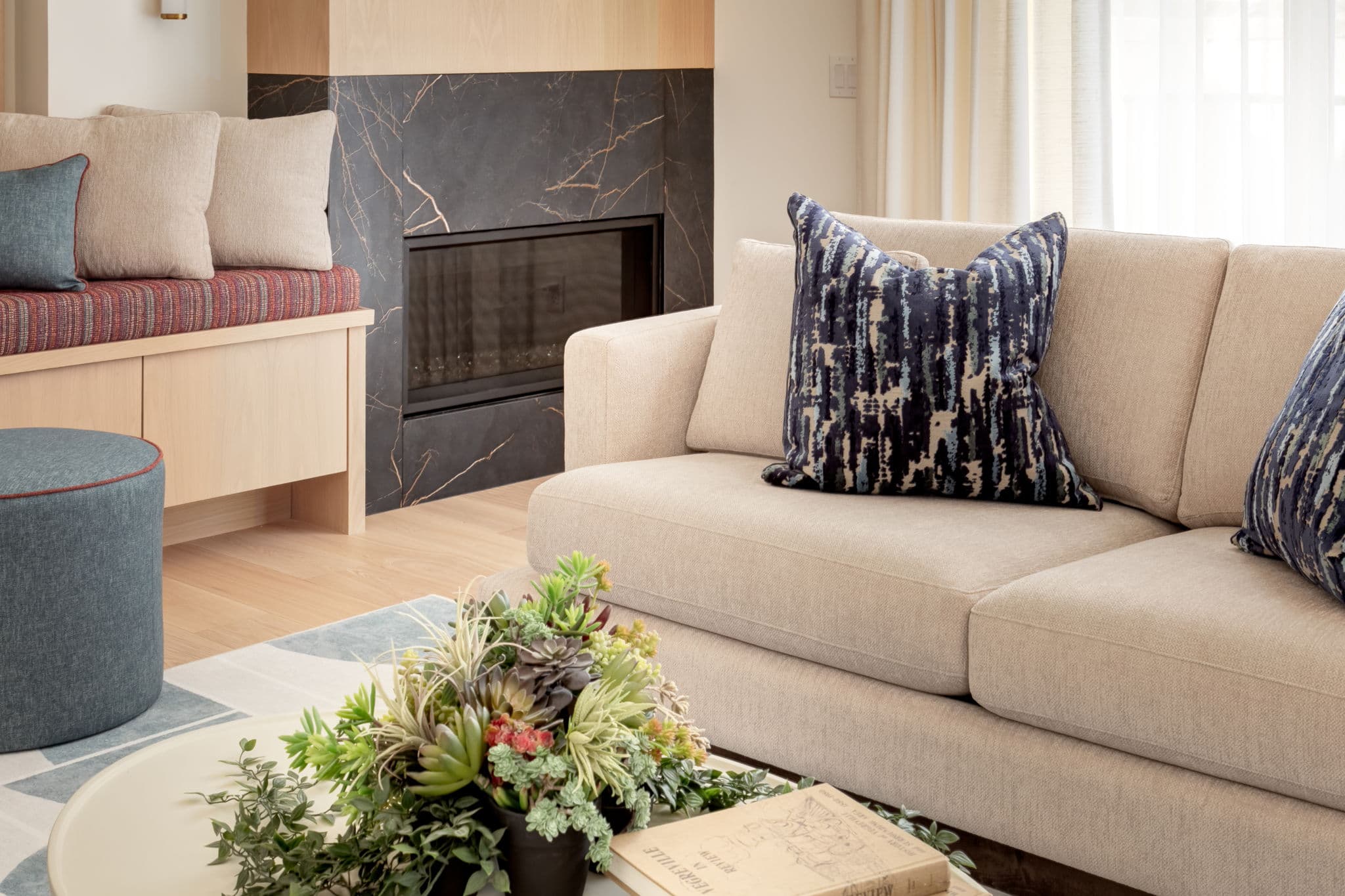 Warm living room fireplace, custom millwork, and seating from the Lakeview 1 project by Platinum Build Homes in Calgary.